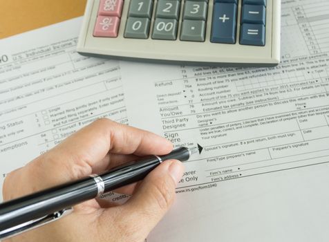 human hands will write in individual income tax return form
