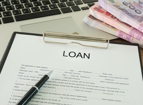 The loan documents and banknotes on desk's bankers.
