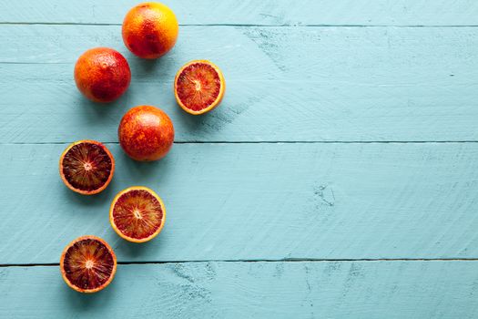 Sanguine orange cutted and whole on blue wooden background view from above