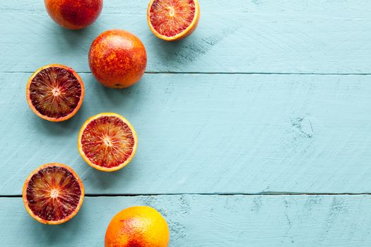 Sanguine orange cutted and whole on blue wooden background view from above