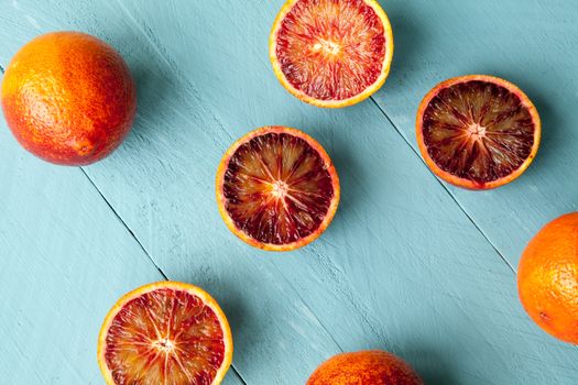 Sanguine orange cutted and whole on blue wooden background view from above