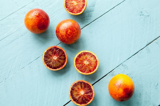 Sanguine orange cutted and whole on blue wooden background view from above