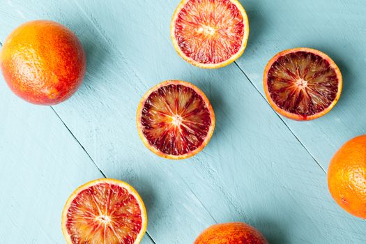 Sanguine orange cutted and whole on blue wooden background view from above