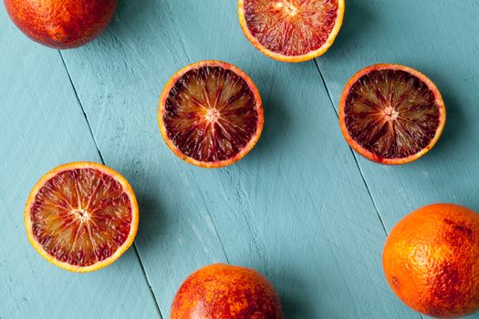 Sanguine orange cutted and whole on blue wooden background view from above