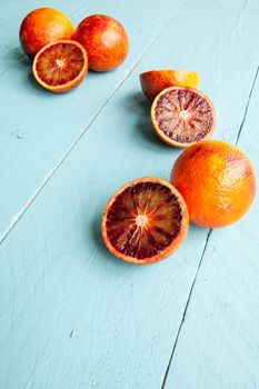 Sanguine orange cutted and whole on blue wooden background view from above