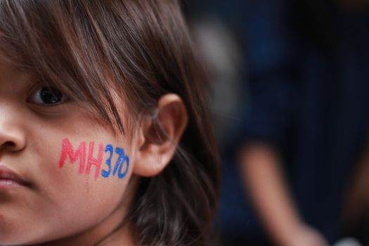 MALAYSIA, Kuala Lumpur: A young demonstrator holds a MH370 tag on her cheek during a rally held in memory of MH370 missing flights victims after almost 2 years on search (on March 8, 2014) at The Square, Publika in Kuala Lumpur on March 6, 2016.