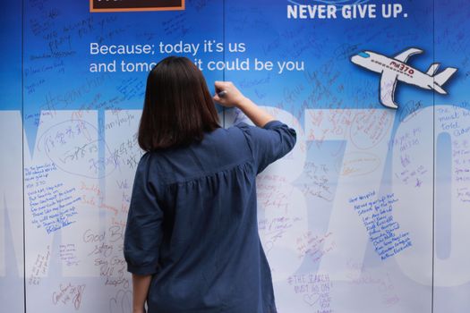 MALAYSIA, Kuala Lumpur: A woman writes on a wall during a rally held in memory of MH370 missing flights victims after almost 2 years on search (on March 8, 2014) at The Square, Publika in Kuala Lumpur on March 6, 2016.