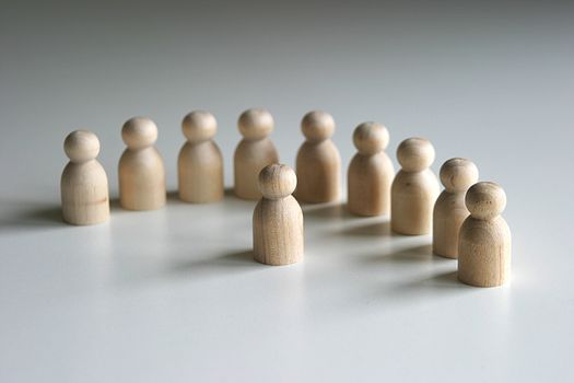 A collection of Wooden peg figures in semi circle with one central figure