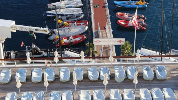 Monte-Carlo, Monaco - January 12, 2016: Rooftop View of the Yacht Club of Monaco. Beach chairs, Boats and Harbor in the south of France