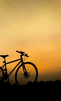 Sunset silhouette and bicycle on beautiful sky