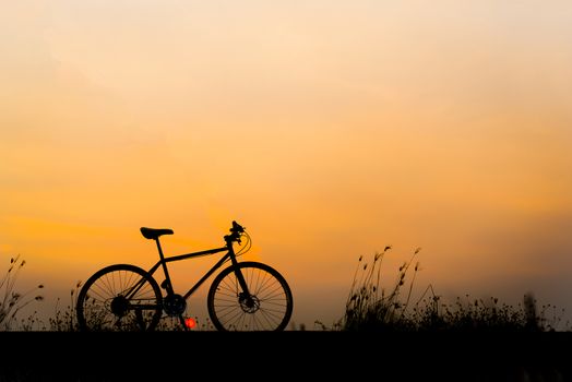 Sunset silhouette and bicycle on beautiful sky