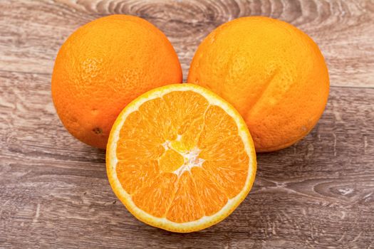 The orange oranges on a brown wooden background