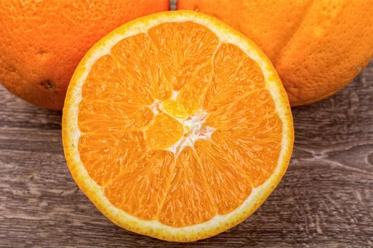 The orange oranges on a brown wooden background