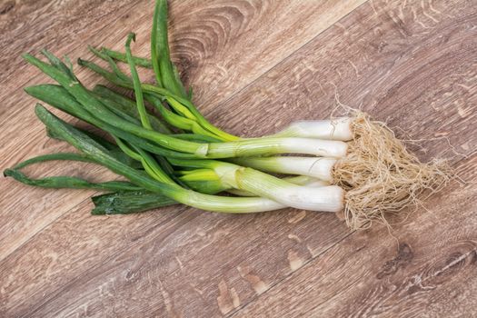 Spring onion on a brown wooden background