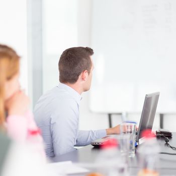 Business man making a presentation at office. Business executive delivering a presentation to his colleagues during meeting or in-house business training, explaining business plans to his employees.