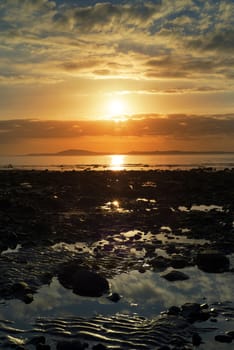 reflections at rocky beal beach near ballybunion on the wild atlantic way ireland with a beautiful yellow sunset