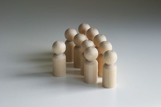 A collection of Wooden peg figures in semi circle with one central figure