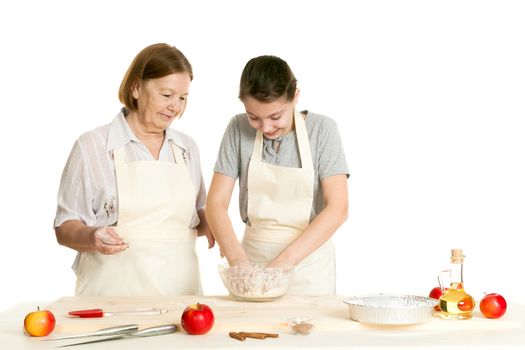 the grandmother and the granddaughter knead dough on a kitchen table