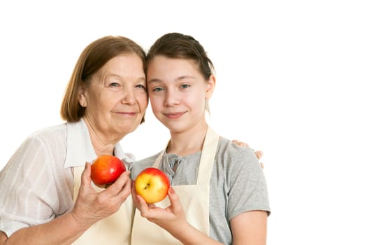 the grandmother and the granddaughter hold beautiful apples in hand