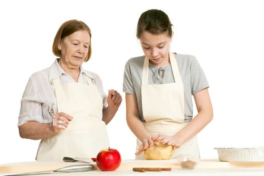 the grandmother and the granddaughter knead dough on a kitchen table