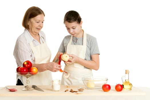 the grandmother and the granddaughter cut off a peel from apple for pie