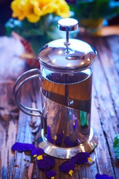 Flower tea in glass pot on a wooden table. spring concept