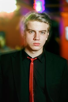 Portrait of a handsome man in a black suit with a red tie. Motion blur light effect.