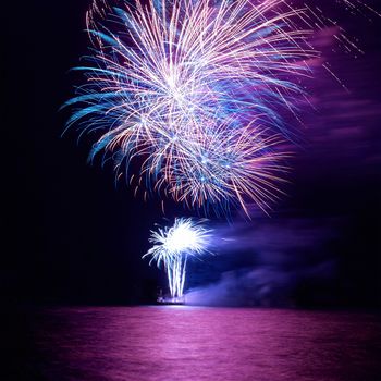 Blue and red colorful holiday fireworks on the black sky background.