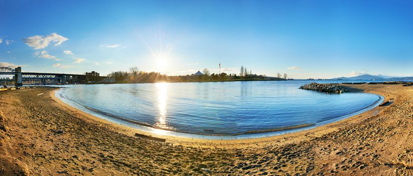 Panoramic view of Vancouver city from the sandy beach side. Sunset above the blue bay