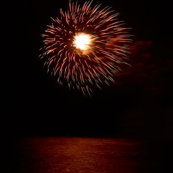 Red colorful holiday fireworks on the black sky background.