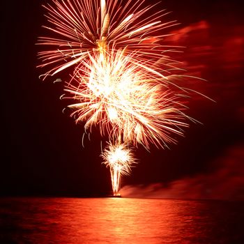 Red colorful holiday fireworks on the black sky background.