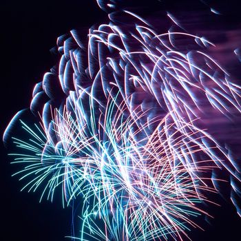 Blue and red colorful holiday fireworks on the black sky background.