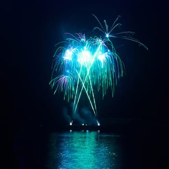 Blue colorful fireworks on the black sky background. Holiday celebration.