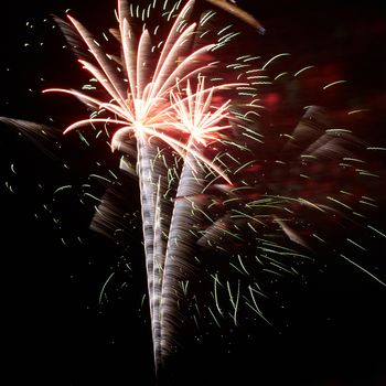 Blue, red and yellow colorful holiday fireworks on the black sky background.