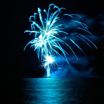 Blue colorful holiday fireworks on the black sky background.