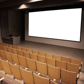 Empty cinema with white isolated screen and brown chairs.