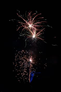 Blue colorful fireworks on the black sky background. Holiday celebration.