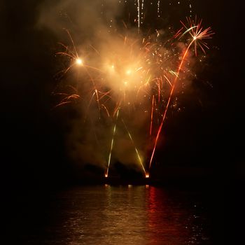 Red colorful fireworks on the black sky background. Holiday celebration.