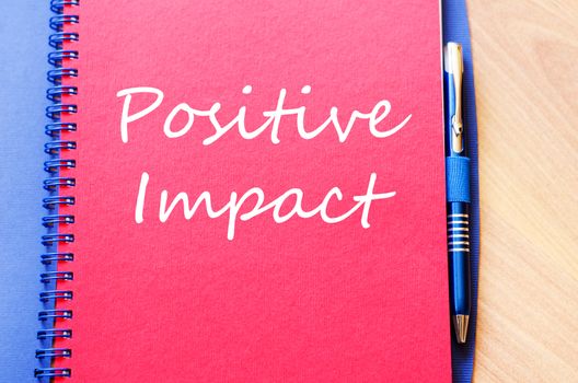 Positive impact text concept write on notebook with pen