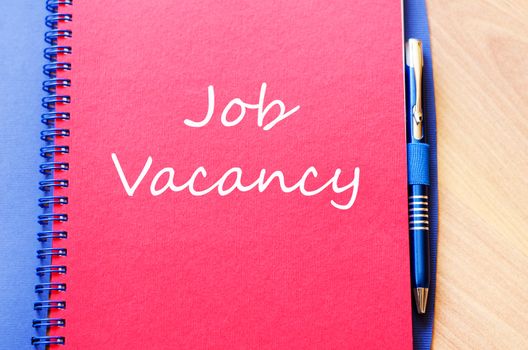 Job vacancy text concept write on notebook with pen