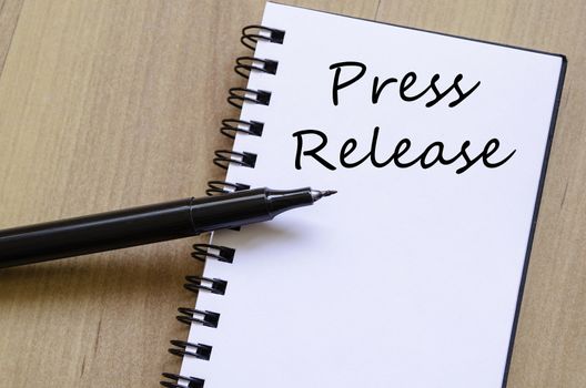 Press release text concept write on notebook with pen