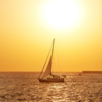 Sail boat against sea sunset. Colorful marine landscape.