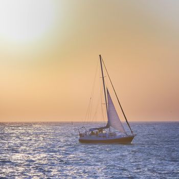 Sail boat against sea sunset. Colorful marine landscape.