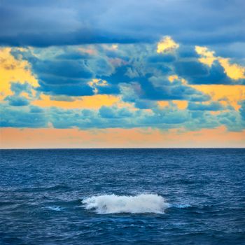 Big wave, colorful sunset over the sea with blue sky and clouds