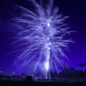 Blue colorful fireworks on night sky background