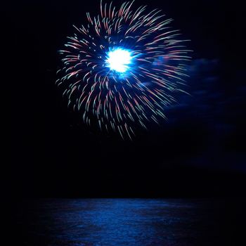 Blue and red colorful holiday fireworks on the black sky background.