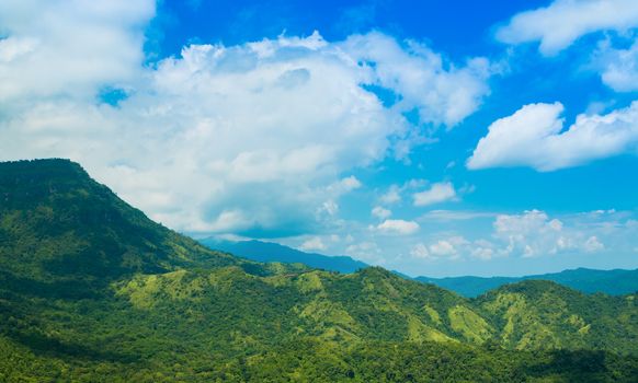 Green mountain with blue sky and clouds background