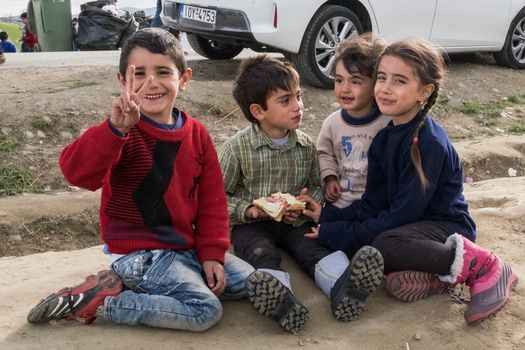 GREECE, Idomeni: Refugee children sit together at the Idomeni refugee camp in Greece on March 7, 2016. Thousands of refugees from the middle east remain stranded at the border of Greece and Macedonia. The situation has gotten worse at the refugee camp at Idomeni. People are living in tents, with no warm water or showers available. 