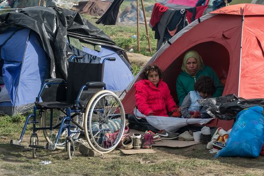 GREECE, Idomeni: Refugees sit in tents at the Idomeni refugee camp in Greece on March 7, 2016. Thousands of refugees from the middle east remain stranded at the border of Greece and Macedonia. The situation has gotten worse at the refugee camp at Idomeni. People are living in tents, with no warm water or showers available. 