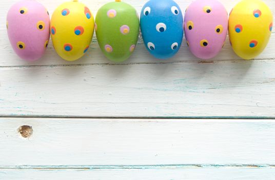 Colorful easter eggs on a white wooden planks